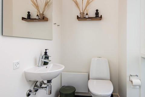 Moderne badkamer met toilet, wastafel en decoratieve rekjes in 8-persoons vakantiehuis in Ansager.