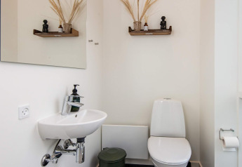 Moderne badkamer met toilet, wastafel en decoratieve planken in 8-persoons vakantiehuis in Ansager.
