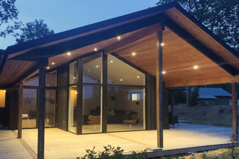 Avondzicht op de elegante leefruimte van het 12-persoons vakantiehuis in Millinge, Denemarken, met terras.