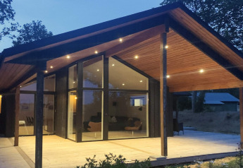 Avondbeeld van de stijlvolle lounge in het 12-persoons vakantiehuis in Millinge, Denemarken, met terras.