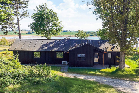 Billede af en feriebolig til 12 personer i Millinge med udsigt over vand og grønne omgivelser.