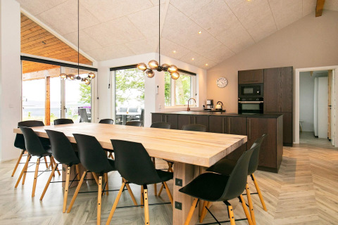 Moderne eet- en keukenruimte in een 12-persoons vakantiehuis in Millinge, Denemarken, met grote ramen.