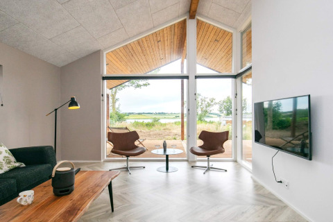 Moderne leefruimte in 12-persoons vakantiehuis in Millinge, Denemarken met grote ramen en uitzicht buiten.