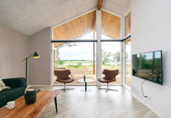 Moderne woonkamer in 12-persoons vakantiewoning in Millinge, Denemarken met grote ramen en mooi uitzicht.