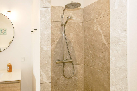 Doccia moderna con soffione a pioggia e piastrelle in marmo beige in casa vacanze per 12 a Millinge, Danimarca.