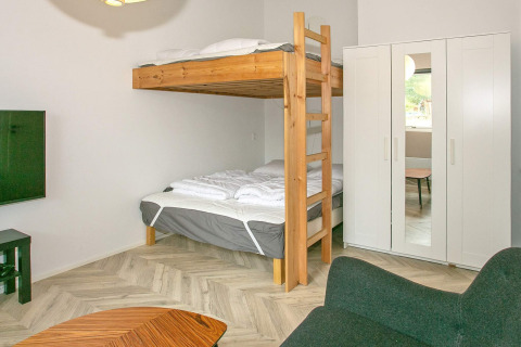 Dormitorio moderno en Millinge, Dinamarca, con literas, armario blanco y ambiente acogedor para familias.