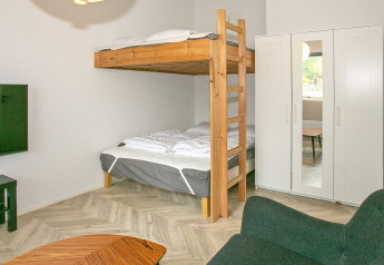 Slaapkamer in modern vakantiehuis in Millinge met stapelbedden, witte kast en gezellige inrichting.