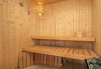 Houten binnen sauna in het 12-persoons vakantiehuis in Millinge, Denemarken, met banken en kachel.