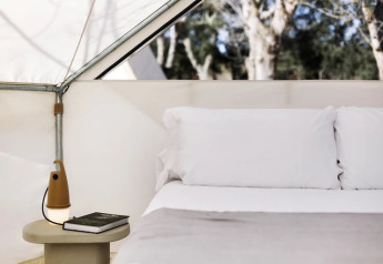 Vista interna della Bell Tent Plus al Wecamp Cala Montgó in Spagna con letto e comodino.