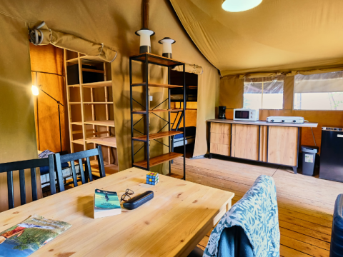 Binnenzicht van safaritent Lodge «COSY» op Ludo Camping in Frankrijk, met keuken en eettafel.