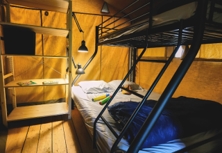 Binnenzicht van safari tent Lodge «COSY» met stapelbed en kast bij Ludo Camping, Frankrijk.