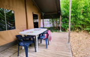 Buitenterras met tafel en stoelen bij Lodge «COSY» safaritent op Ludo Camping in Frankrijk.