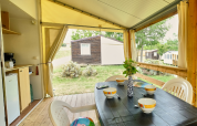 Safari-Zelt 'Bungalowtent' auf Ludo Camping in Frankreich mit gedecktem Tisch auf der Terrasse.