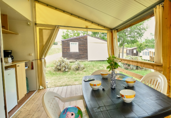 Safari-Zelt 'Bungalowtent' auf Ludo Camping in Frankreich mit gedecktem Tisch auf der Terrasse.