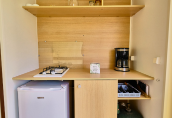 Piccolo angolo cottura in una Bungalowtent al Ludo Camping con fornello a gas, macchina da caffè e frigorifero.