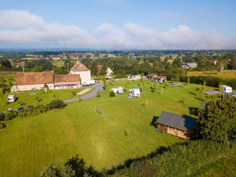 Luftfoto af La Maison Bornat feriepark med grønne marker og bygninger i Bourgogne-Franche-Comté, Frankrig.