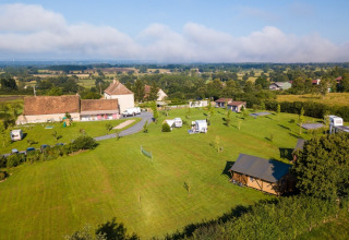 Aerial view of La Maison Bornat holiday park featuring green fields and farm buildings in eastern France.