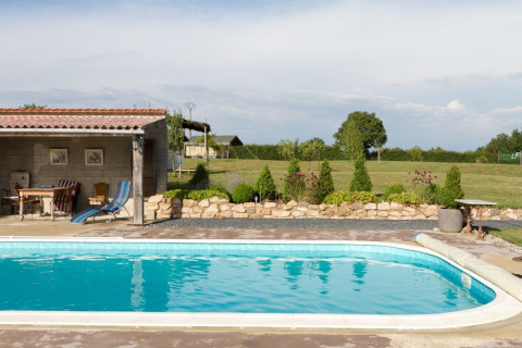 Outdoor swimming pool with terrace and garden at La Maison Bornat holiday park in Bourgogne-Franche-Comté, France.