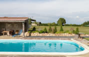 Outdoor swimming pool with terrace and garden at La Maison Bornat holiday park in Bourgogne-Franche-Comté, France.