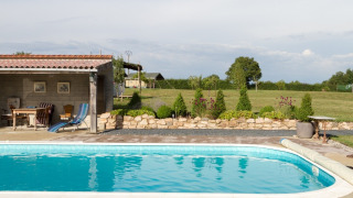 Buitenzwembad met terras en tuin bij vakantiepark La Maison Bornat in Bourgogne-Franche-Comté, Frankrijk.