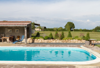 Buitenzwembad met terras en tuin bij vakantiepark La Maison Bornat in Bourgogne-Franche-Comté, Frankrijk.