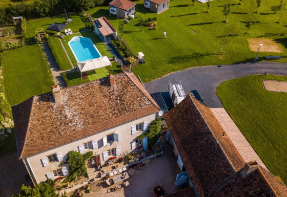 Aerial view of La Maison Bornat holiday park in Bourgogne-Franche-Comté, France, featuring pool and gardens.