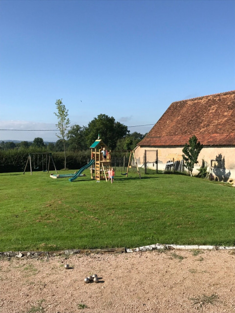 Speelplaats bij La Maison Bornat met schommels en glijbaan in Bourgogne-Franche-Comté, Frankrijk.