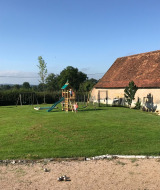 Legeplads i La Maison Bornat med gynger, rutsjebane og legepladsudstyr i Bourgogne-Franche-Comté, Frankrig.