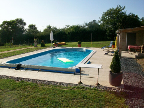 Buitenzwembad bij La Maison Bornat met ligstoelen en groene tuin in Bourgogne-Franche-Comté, Frankrijk.