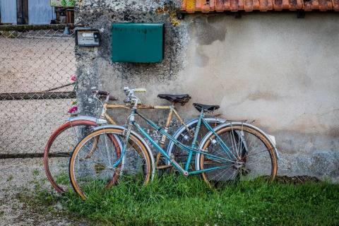 To gamle cykler lænet op ad en mur i La Maison Bornat feriepark, Bourgogne-Franche-Comté, Frankrig.