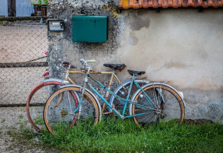 Due biciclette d'epoca appoggiate a un muro al parco vacanze La Maison Bornat, Bourgogne-Franche-Comté, Francia.