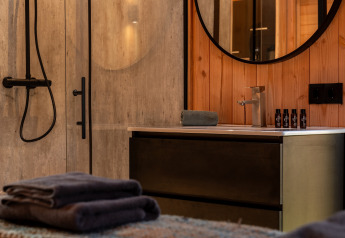 Bagno moderno al Wellness Duynzicht, Sandberghe, Paesi Bassi, con asciugamani e articoli da bagno.