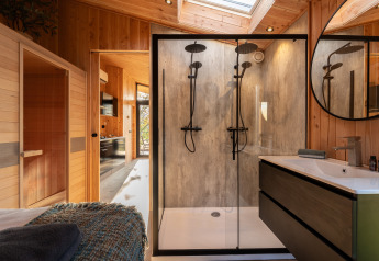 Moderne badkamer met dubbele regendouches, sauna en hout bij Wellness Duynzicht in Sandberghe.