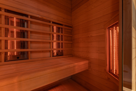 Innenansicht einer Infrarotsauna mit Holzbänken im Wellness Duynzicht, Sandberghe, Niederlande, warme Atmosphäre.