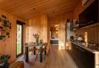 Moderno lodge Wellness Duynzicht a Sandberghe, Paesi Bassi, con interni in legno e cucina a vista.