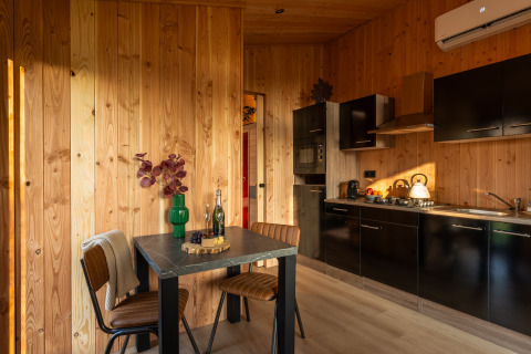 Moderne keuken en eetruimte in houten lodge bij Wellness Duynzicht in Sandberghe, Nederland.