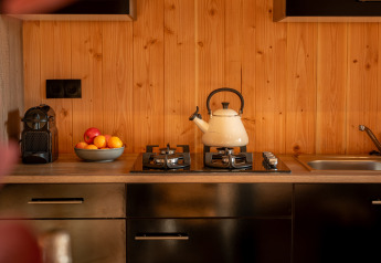 Moderne lodgekeuken met waterketel, fruitschaal, koffiemachine en gootsteen bij Wellness Duynzicht, Sandberghe.