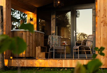 Buitenterras aan de lodge Wellness Duynzicht in Sandberghe, Nederland, met zitplaatsen en houten hottub.
