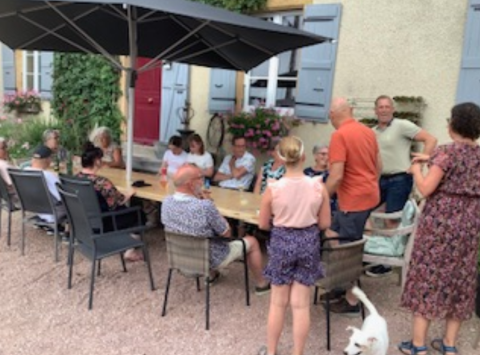 Gruppe von Menschen sitzt an einem Tisch bei La Maison Bornat, einem Ferienpark in Bourgogne, Frankreich.