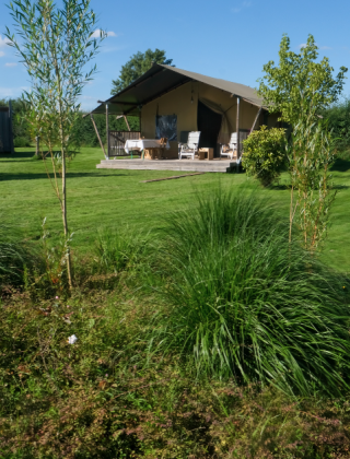 Idyllisk udsigt over La Maison Bornat feriepark i Bourgogne, Frankrig, med grønne områder og bungalow.