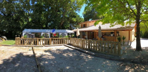Sunny terrace and outdoor dining area at Campsite Les Franquettes in Nouvelle-Aquitaine, France.