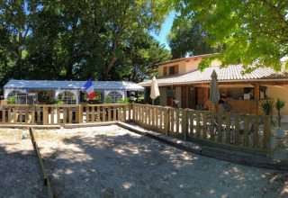 Terrazza soleggiata e area esterna al campeggio Les Franquettes in Nouvelle-Aquitaine, Francia.