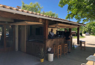 Bar all'aperto presso il campeggio Les Franquettes in Nouvelle-Aquitaine, Francia, con due persone dietro il bancone.
