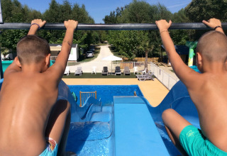 Due bambini pronti a scendere dallo scivolo d'acqua nella piscina del campeggio Les Franquettes in Francia.