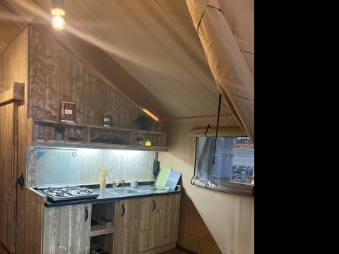 Innenansicht einer rustikalen Küche in einem Safarizelt, Lodge Woody 27, auf dem Campingplatz Les Franquettes in Frankreich.