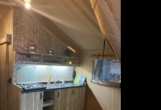 Innenansicht einer rustikalen Küche in einem Safarizelt, Lodge Woody 27, auf dem Campingplatz Les Franquettes in Frankreich.