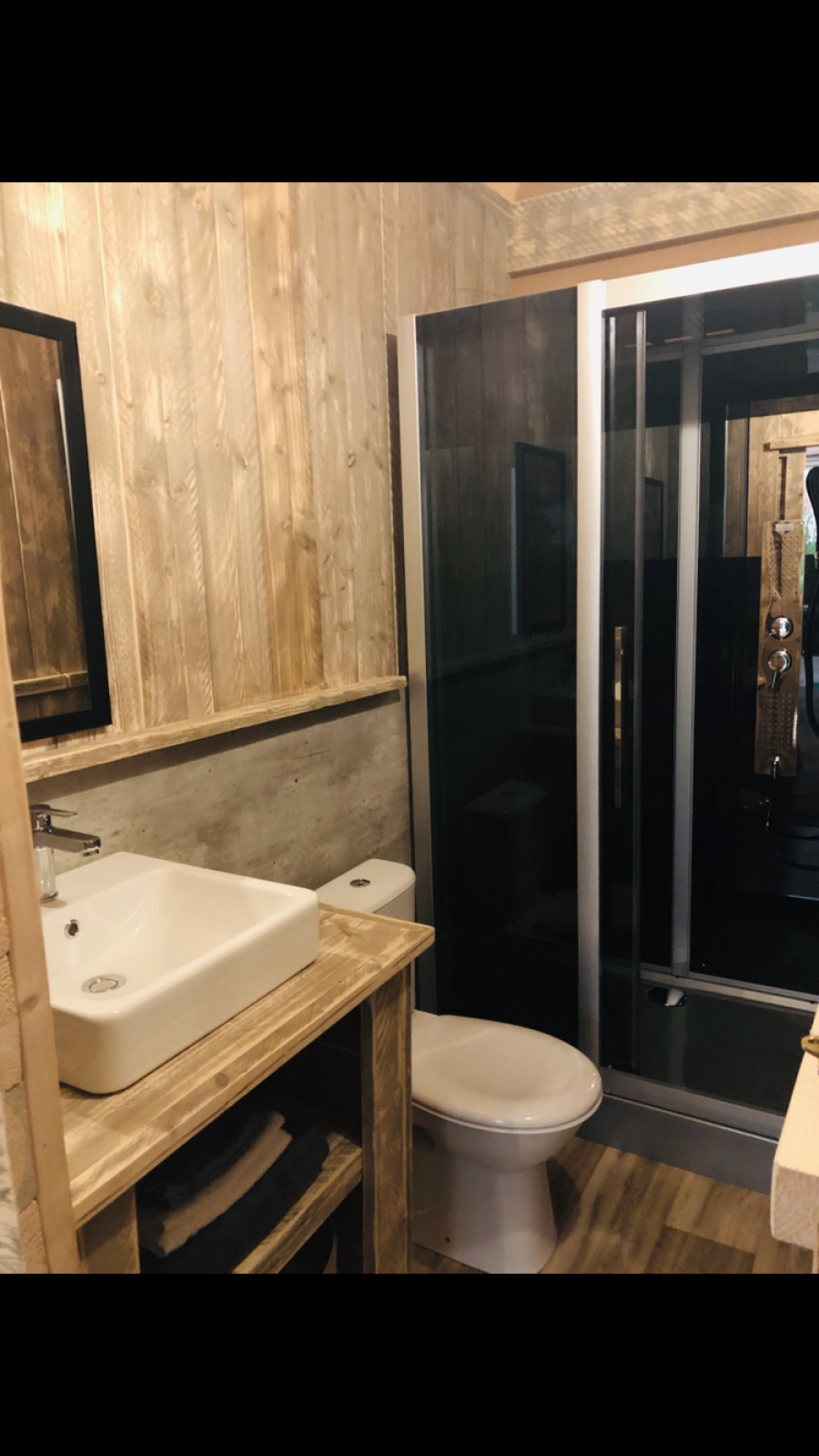 Badkamer in safaritent Lodge Woody 27 op Camping Les Franquettes in Frankrijk met houten accenten.