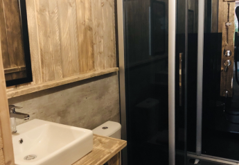Salle de bain dans la tente safari Lodge Woody 27 au Camping Les Franquettes en France, décor bois.