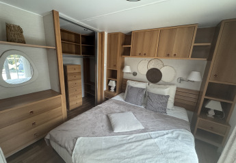 Bedroom in a Premium Mobile Home at Campsite Les Franquettes in France, featuring double bed and wood decor.
