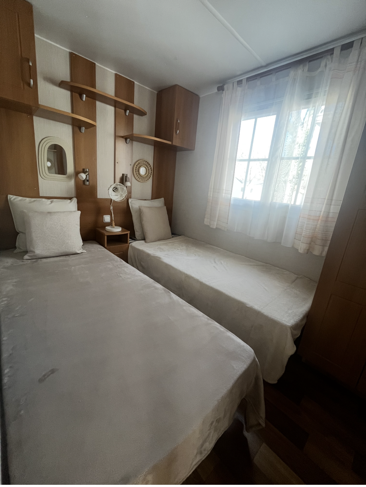 Kamer met twee eenpersoonsbedden en houten kasten in Premium Mobile Home op Camping Les Franquettes in Frankrijk.